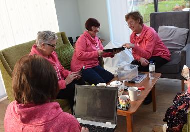 Residents at Bishop Ramsay Court enjoying a cup of tea and biscuits, while using their laptops and tablets